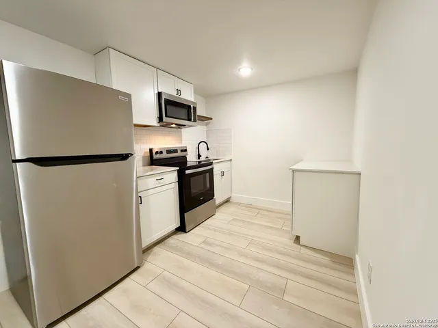 a kitchen with stainless steel appliances granite countertop a refrigerator a stove top oven a sink and dishwasher