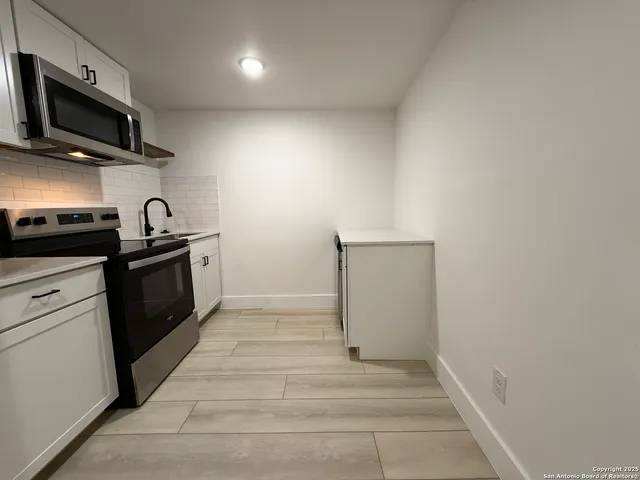 a kitchen with granite countertop a sink and steel appliances