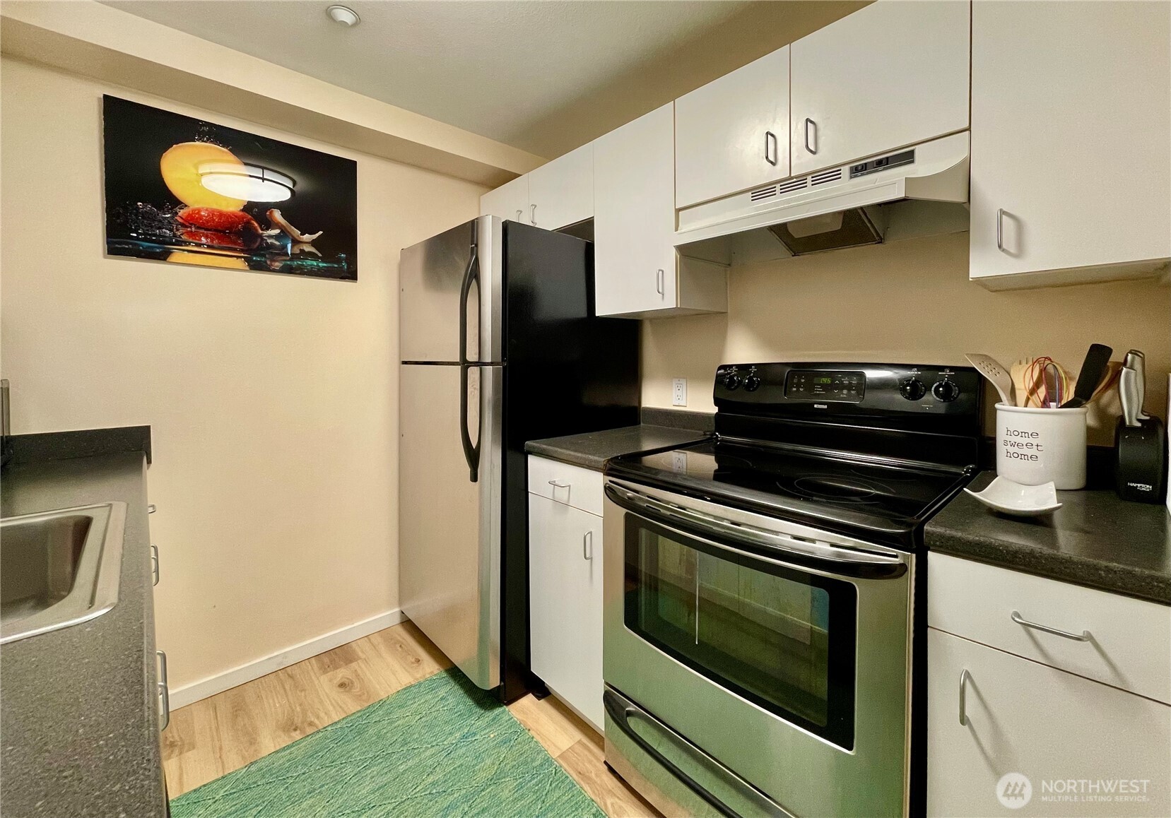 1415 2nd Avenue, Unit 1106 Seattle, WA 98101 - Photo 15 of 30 a kitchen with stainless steel appliances a stove a microwave and a refrigerator