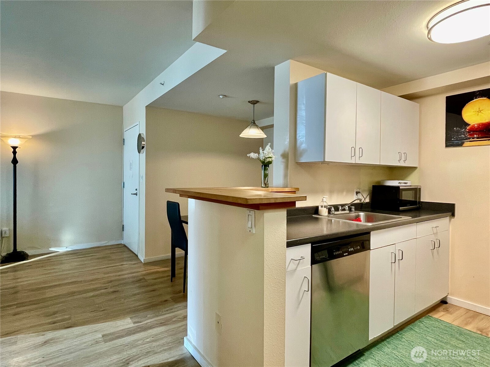 1415 2nd Avenue, Unit 1106 Seattle, WA 98101 - Photo 17 of 30 a kitchen with a sink cabinets and wooden floor