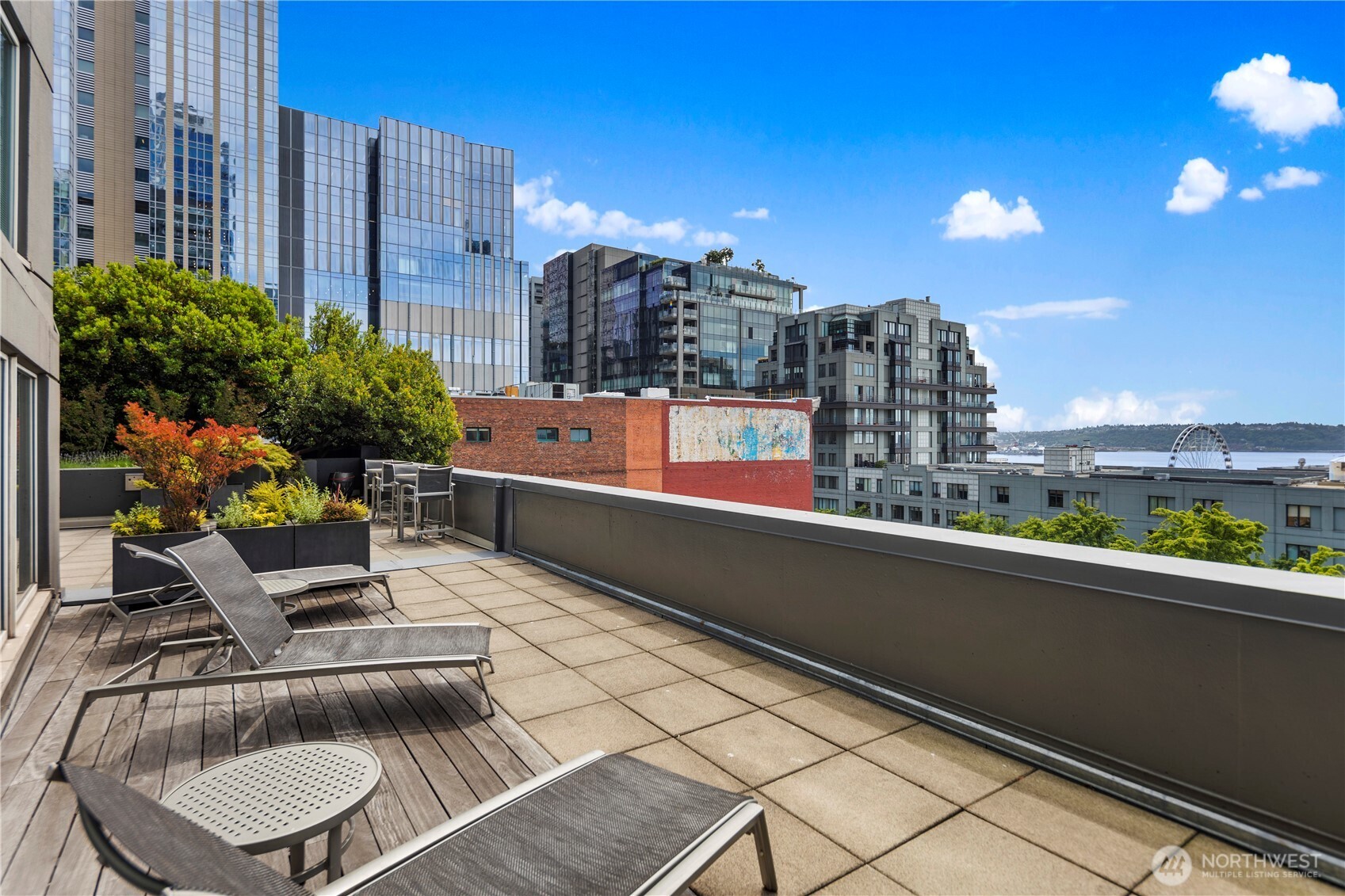 1415 2nd Avenue, Unit 1106 Seattle, WA 98101 - Photo 6 of 30 a roof deck with couch and potted plants