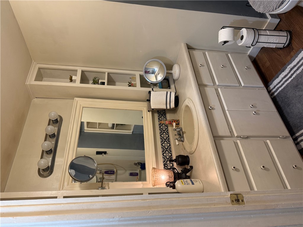 615 Taylor Street Central, SC 29630 - Photo 12 of 16 This functional bathroom features a single vanity, open shelving on the sides, offering practical space and a well-lit mirror.