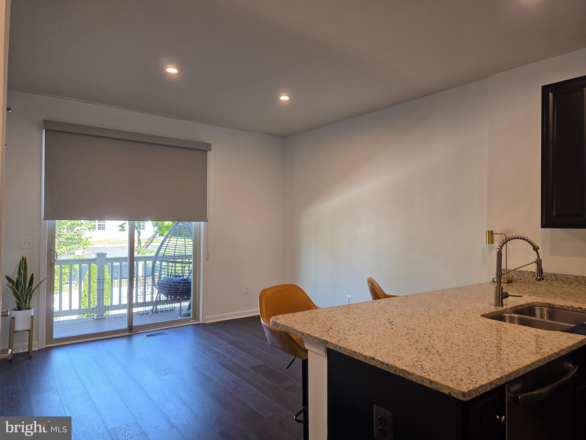 43815 Stubble Cor Square Ashburn, VA 20147 - Photo 4 of 23 a kitchen with a sink a wooden floor and a large window