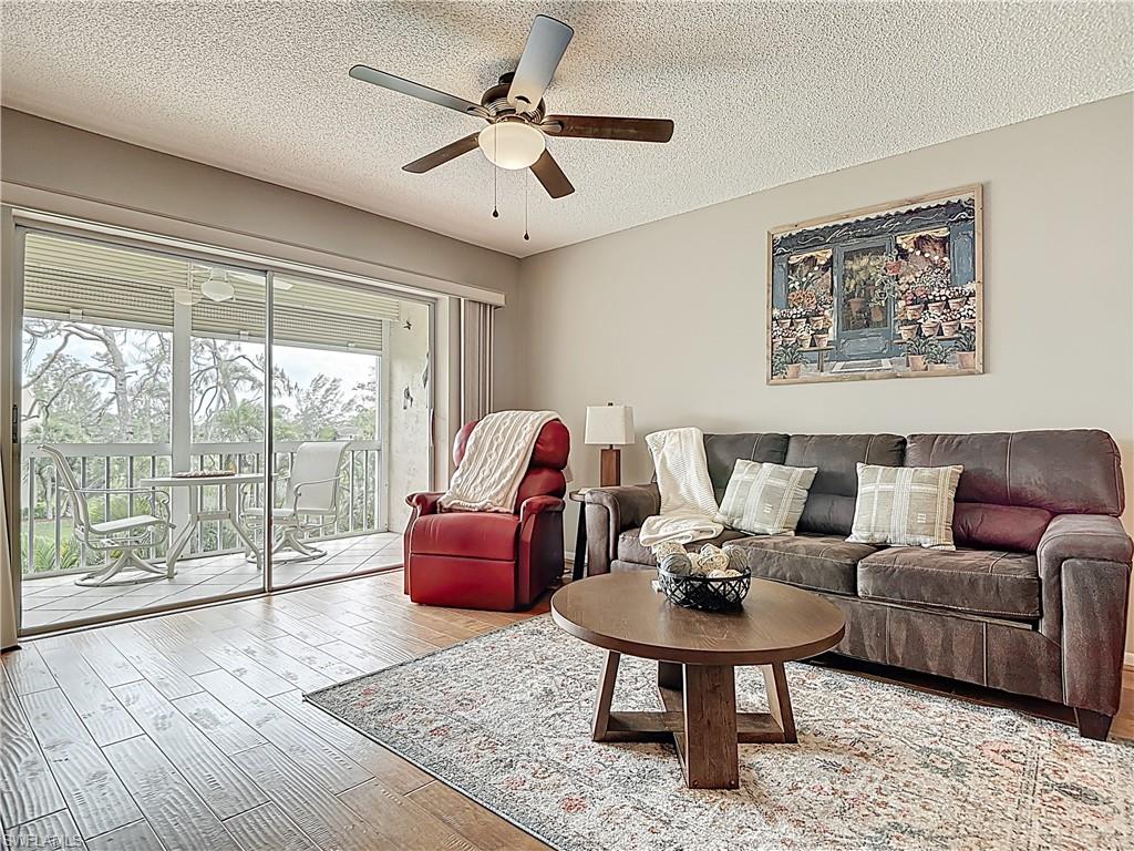 150 Turtle Lake Court, Unit 309 Naples, FL 34105 - Photo 17 of 42 a living room with furniture and a large window