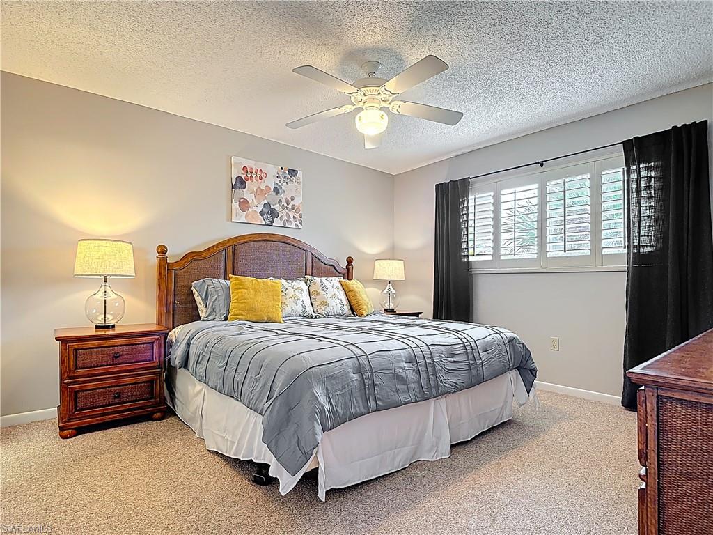 150 Turtle Lake Court, Unit 309 Naples, FL 34105 - Photo 25 of 42 a bedroom with a bed and a chandelier