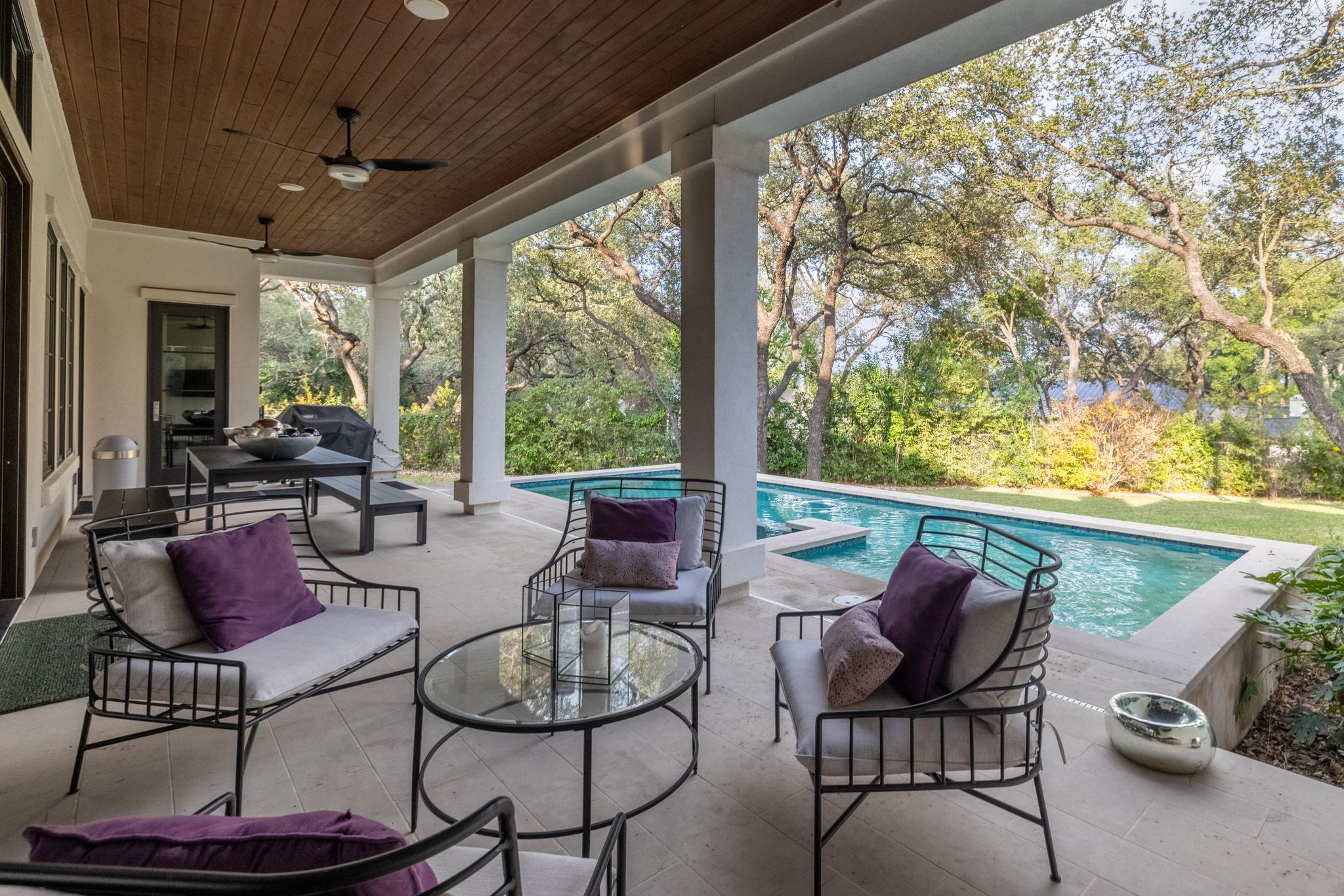 4720 Rockcliff Road, Unit 1 Austin, TX 78746 - Photo 4 of 39 An inviting covered patio offers a private pool and serene wooded backdrop, perfect for outdoor relaxation.