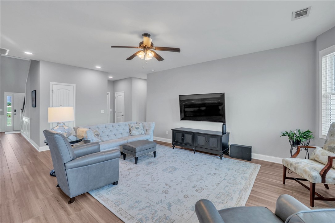 Smooth wood-look flooring and recessed lighting define this comfortable central living area.