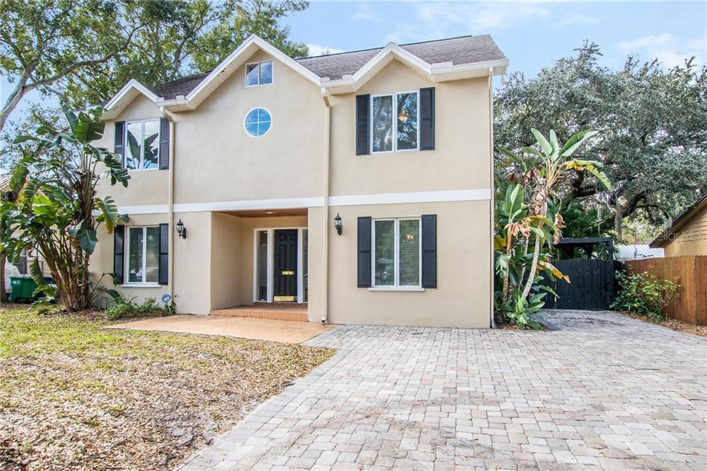 Welcome to Port Tampa!  This 3-story home has an oversized paver driveway that can accommodate multiple cars or an RV.   A covered carport is located behind the gate on the property's north side.