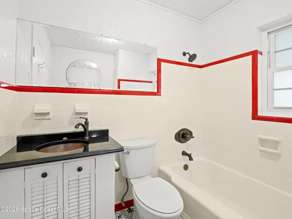 a bathroom with a granite countertop sink mirror vanity and toilet