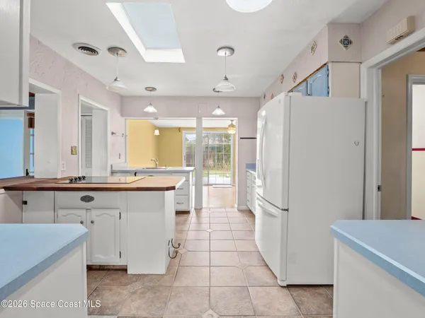 a kitchen with a sink a refrigerator and cabinets
