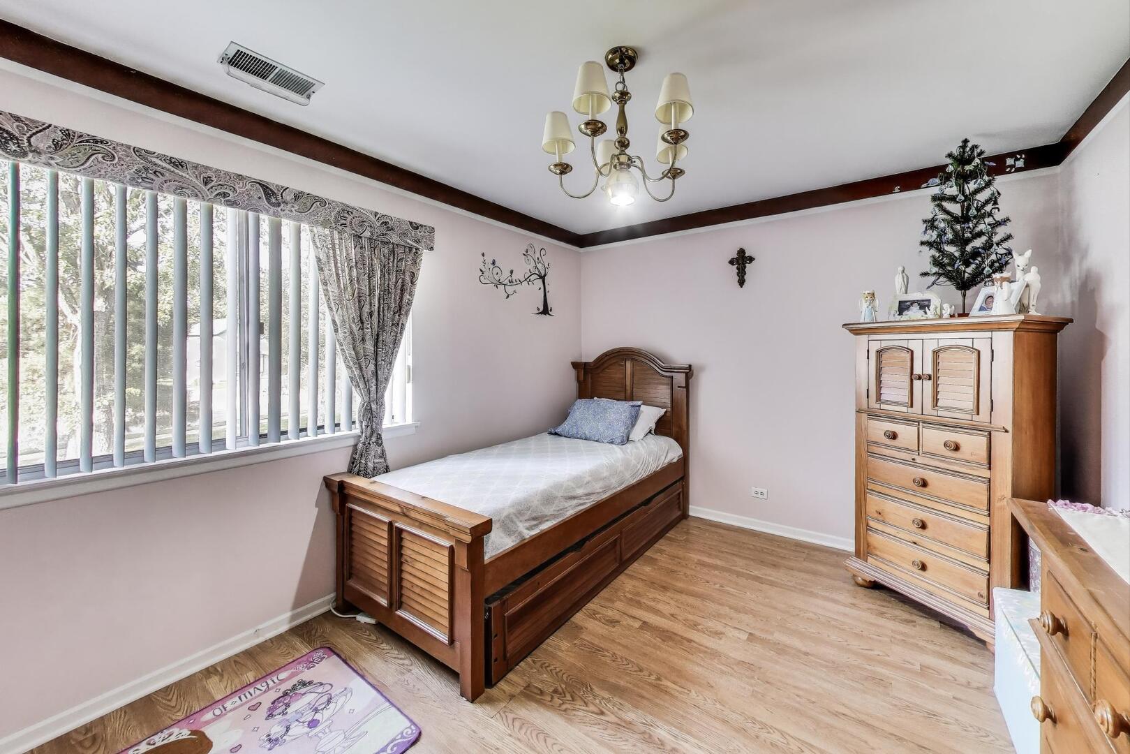 350 Newgate Court, Unit 2Z Schaumburg, IL 60193 - Photo 10 of 18 a bedroom with a bed and a chandelier