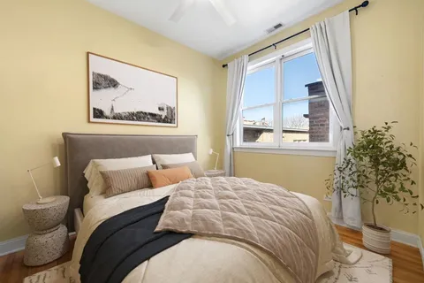 a bedroom with a bed and a painting on the wall