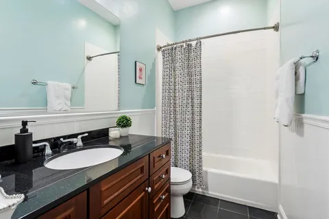 a bathroom with a granite countertop sink toilet and shower