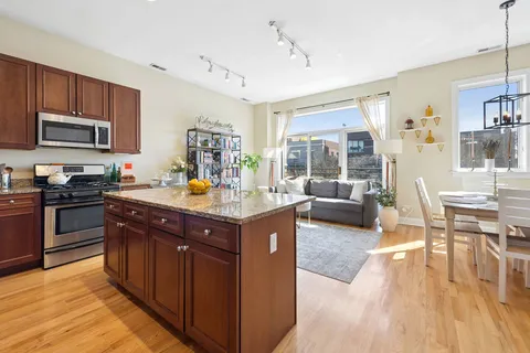 a kitchen with stainless steel appliances granite countertop sink stove top oven and cabinets