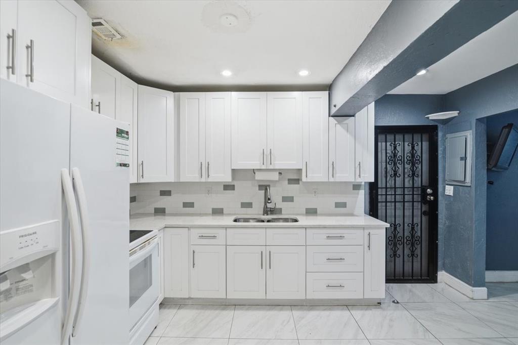 1320 Northwest 86th Street Miami, FL 33147 - Photo 1 of 41 a kitchen with white cabinets and stainless steel appliances