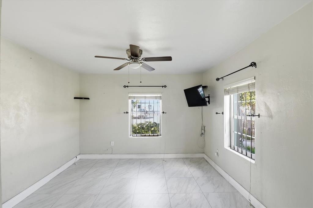 1320 Northwest 86th Street Miami, FL 33147 - Photo 20 of 41 an empty room with windows and chandelier fan