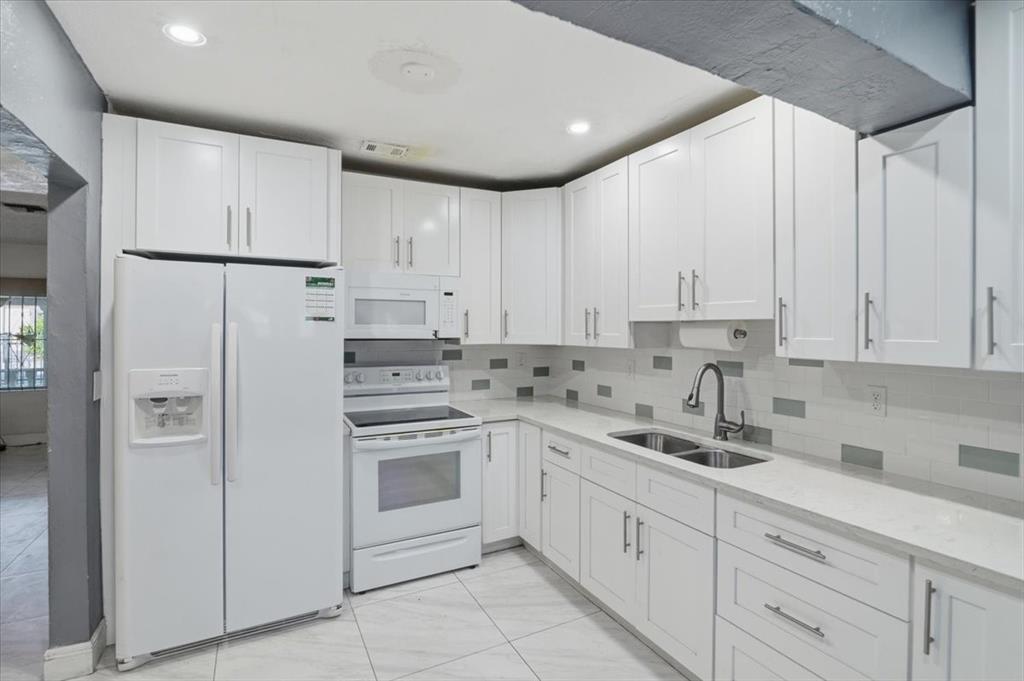 1320 Northwest 86th Street Miami, FL 33147 - Photo 2 of 41 a kitchen with white cabinets and white appliances