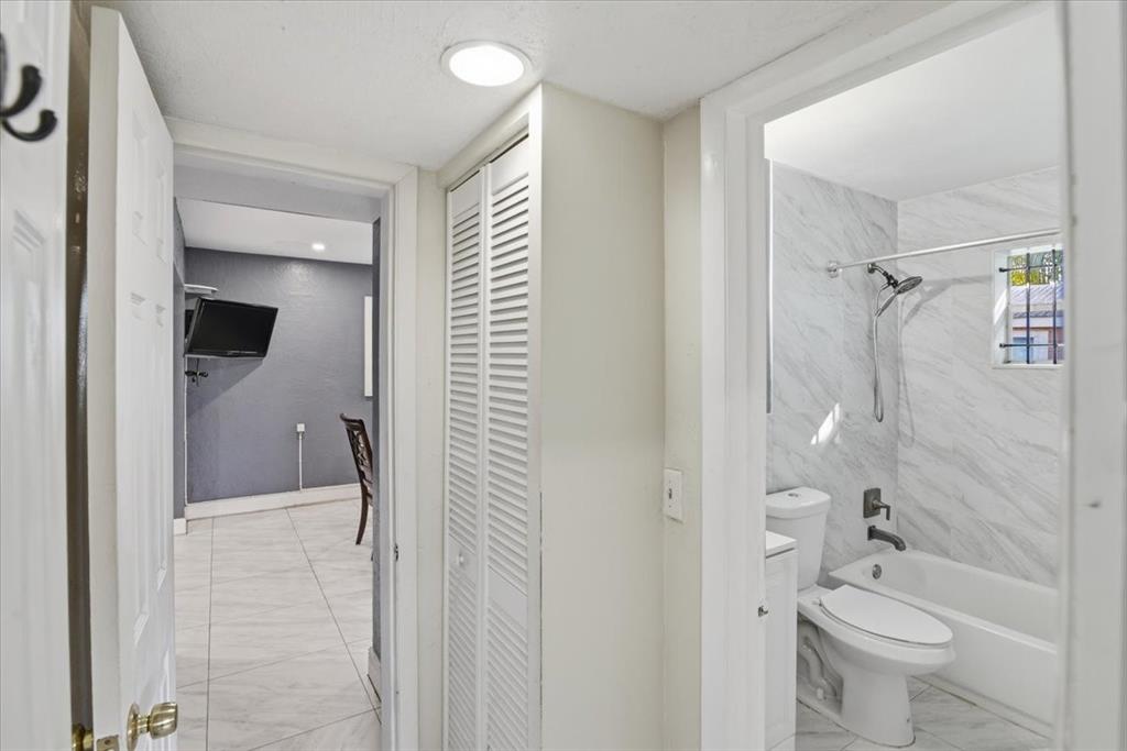 1320 Northwest 86th Street Miami, FL 33147 - Photo 22 of 41 a bathroom with a granite countertop toilet a sink and a mirror