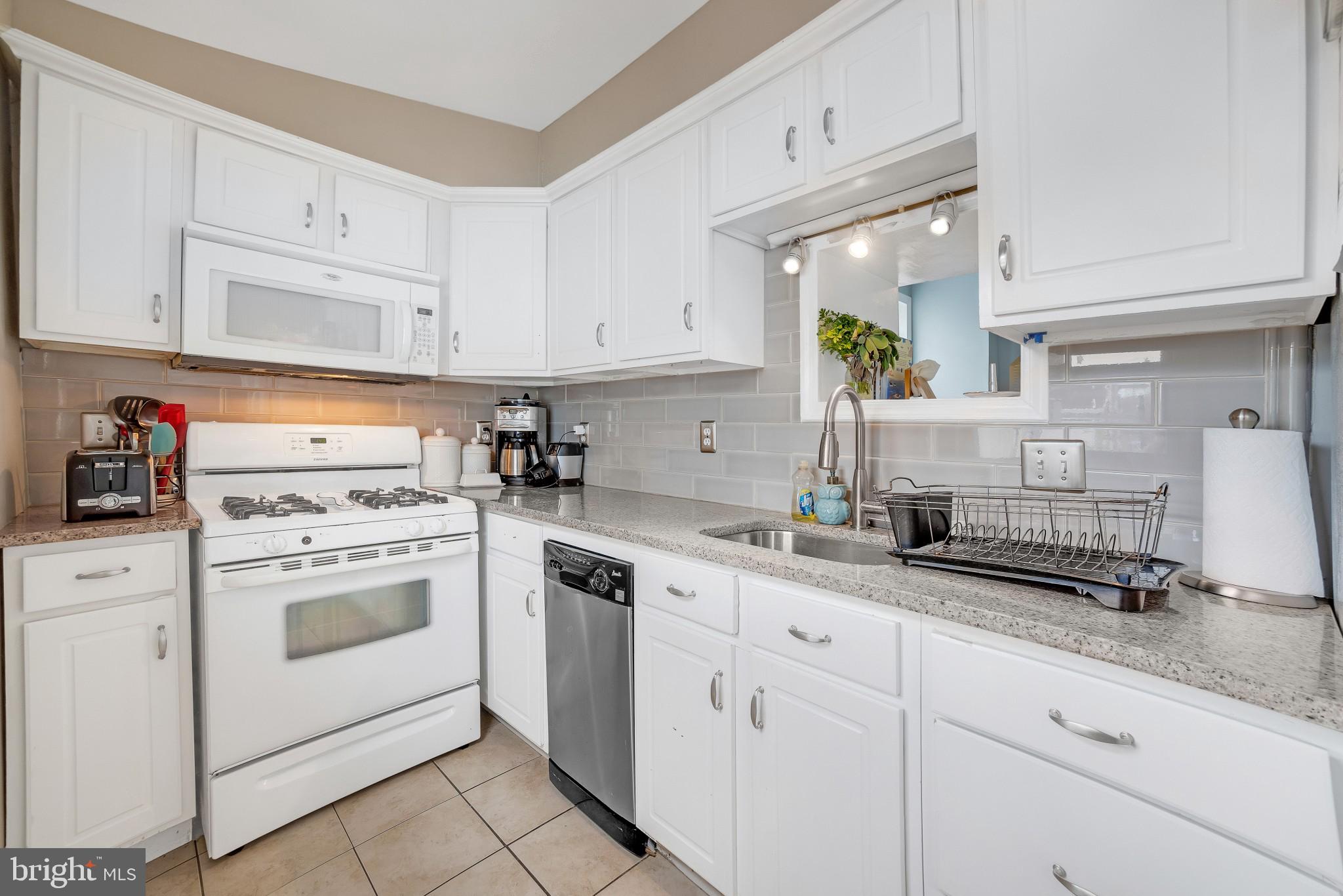 337 Lemonte Street Philadelphia, PA 19128 - Photo 8 of 18 a kitchen with white cabinets and white appliances