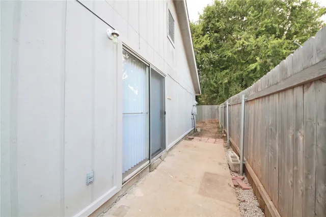 a view of a pathway of a white building with wooden fence
