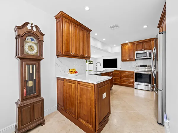 a view of kitchen with cabinets and refrigerator