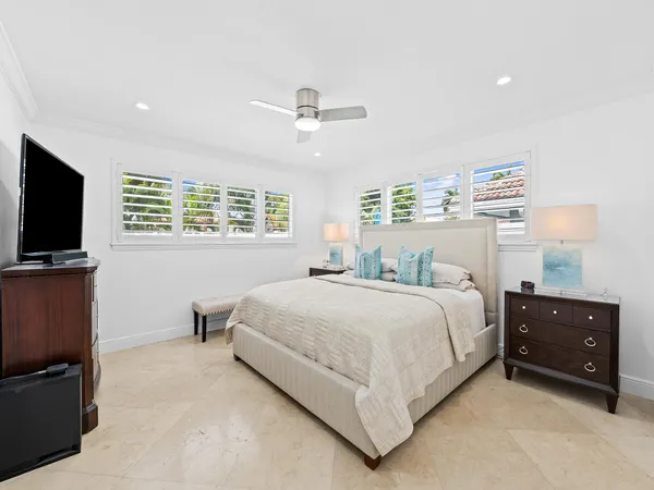 a bedroom with a bed and a flat tv screen on dresser