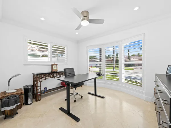 a view of a workspace with furniture and a window