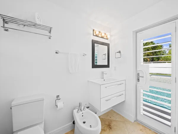 a bathroom with a toilet a sink and mirror