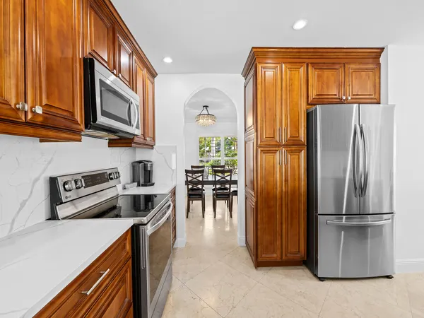 a kitchen with stainless steel appliances granite countertop a refrigerator and a stove top oven