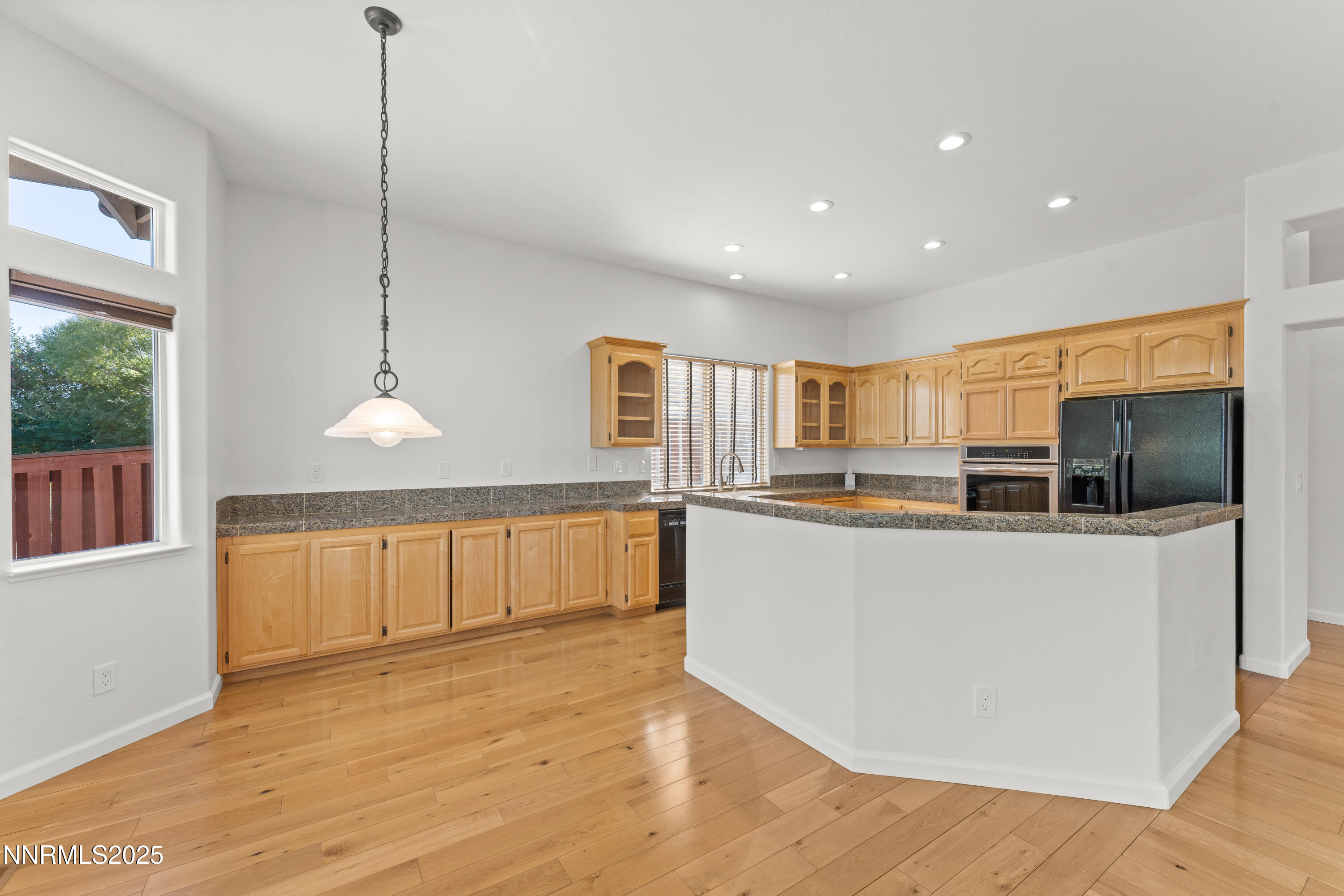 4991 West Albuquerque Road Reno, NV 89511 - Photo 12 of 60 a living room with stainless steel appliances kitchen island granite countertop a refrigerator a oven a sink and a wooden floors