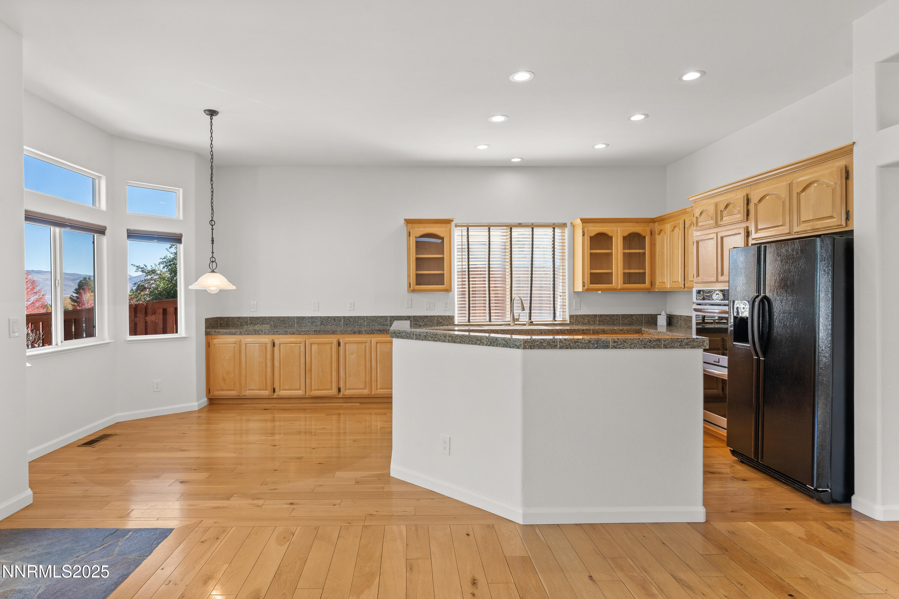 4991 West Albuquerque Road Reno, NV 89511 - Photo 13 of 60 a kitchen with stainless steel appliances granite countertop a refrigerator a stove and a wooden floors