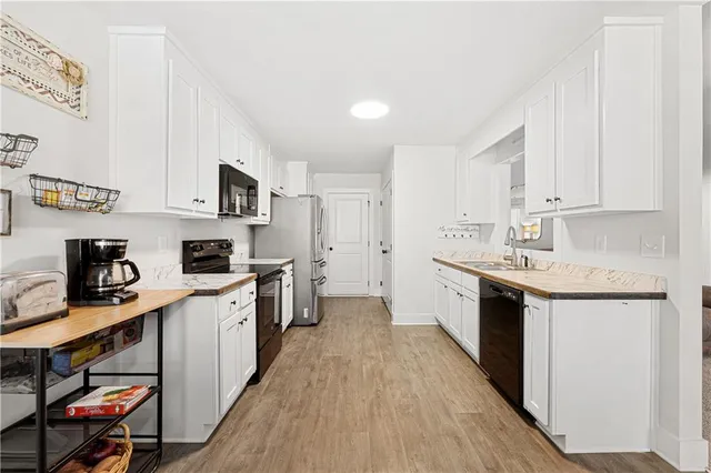 a kitchen with stainless steel appliances granite countertop a sink stove and cabinets