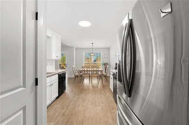 a kitchen with sink a refrigerator and wooden floor