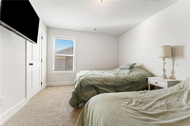 a bed sitting in a bedroom next to a window