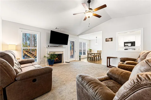 a living room with furniture a flat screen tv and a fireplace