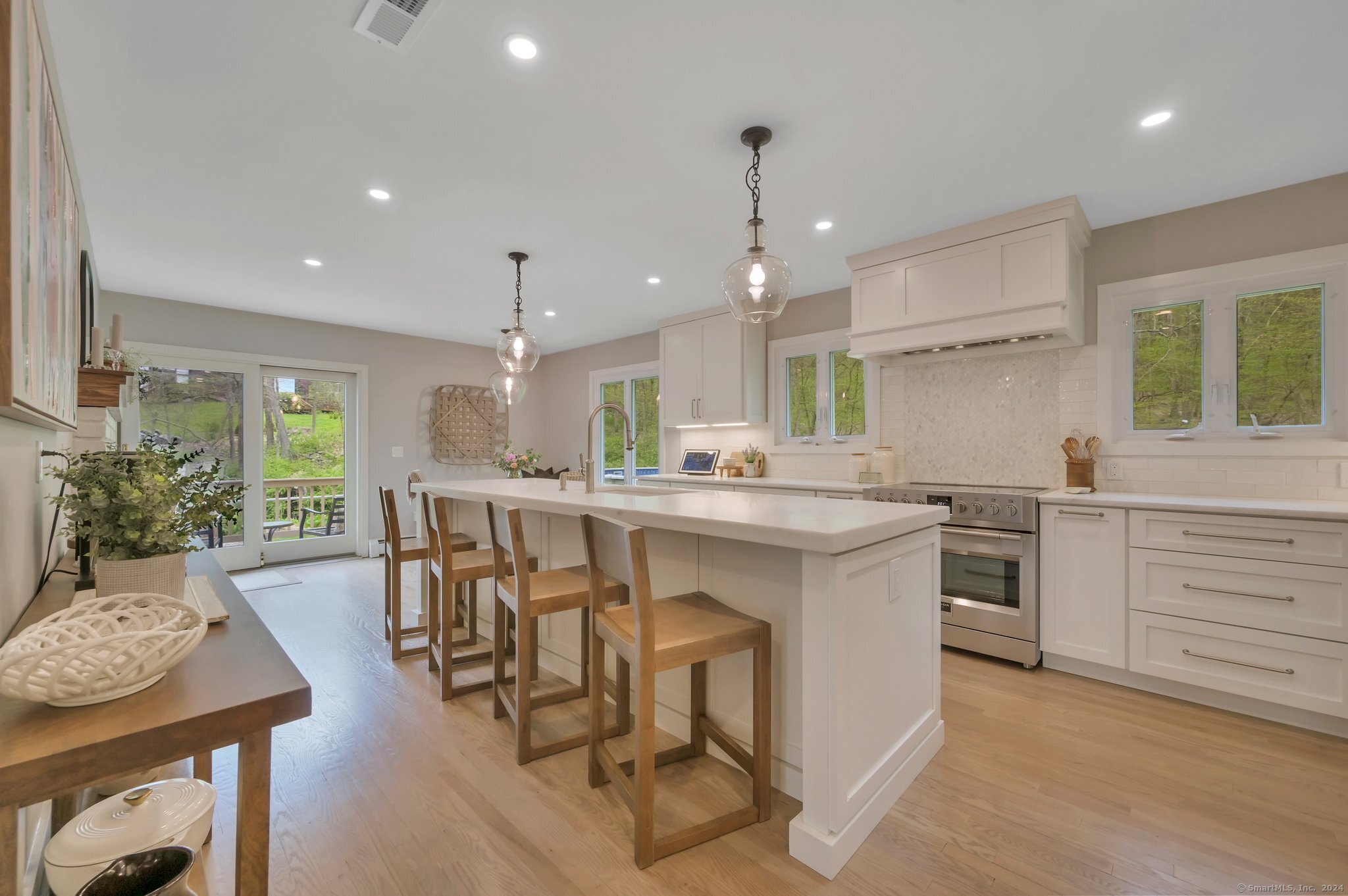 a kitchen with kitchen island a dining table chairs sink and stove