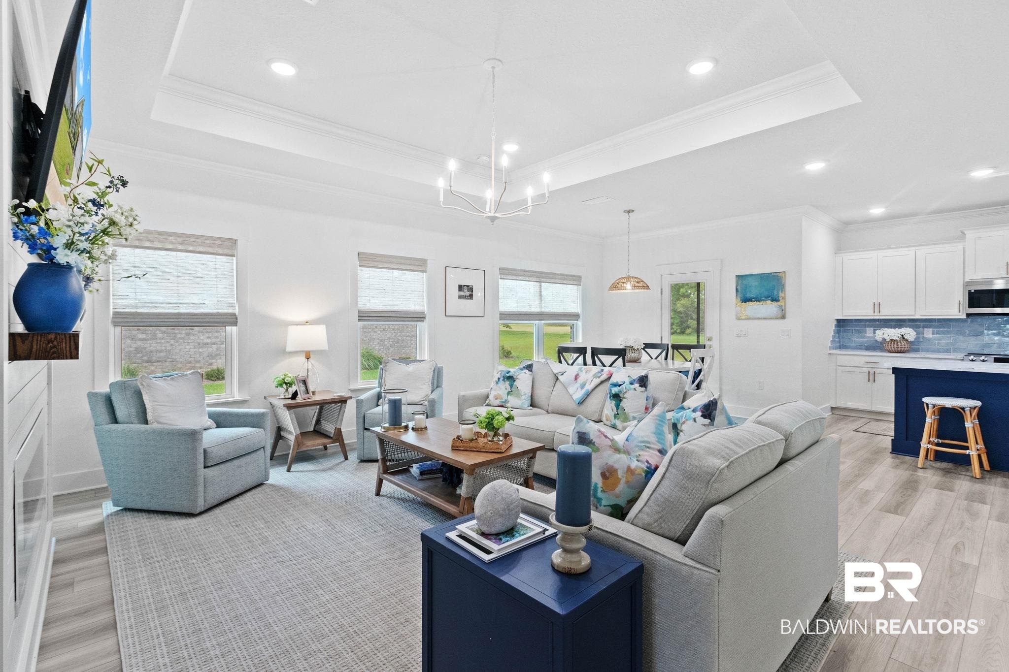 9815 Lakeview Drive Foley, AL 36535 - Photo 15 of 100 Living room featuring an inviting chandelier, a raised ceiling, ornamental molding, and light hardwood / wood-style floors