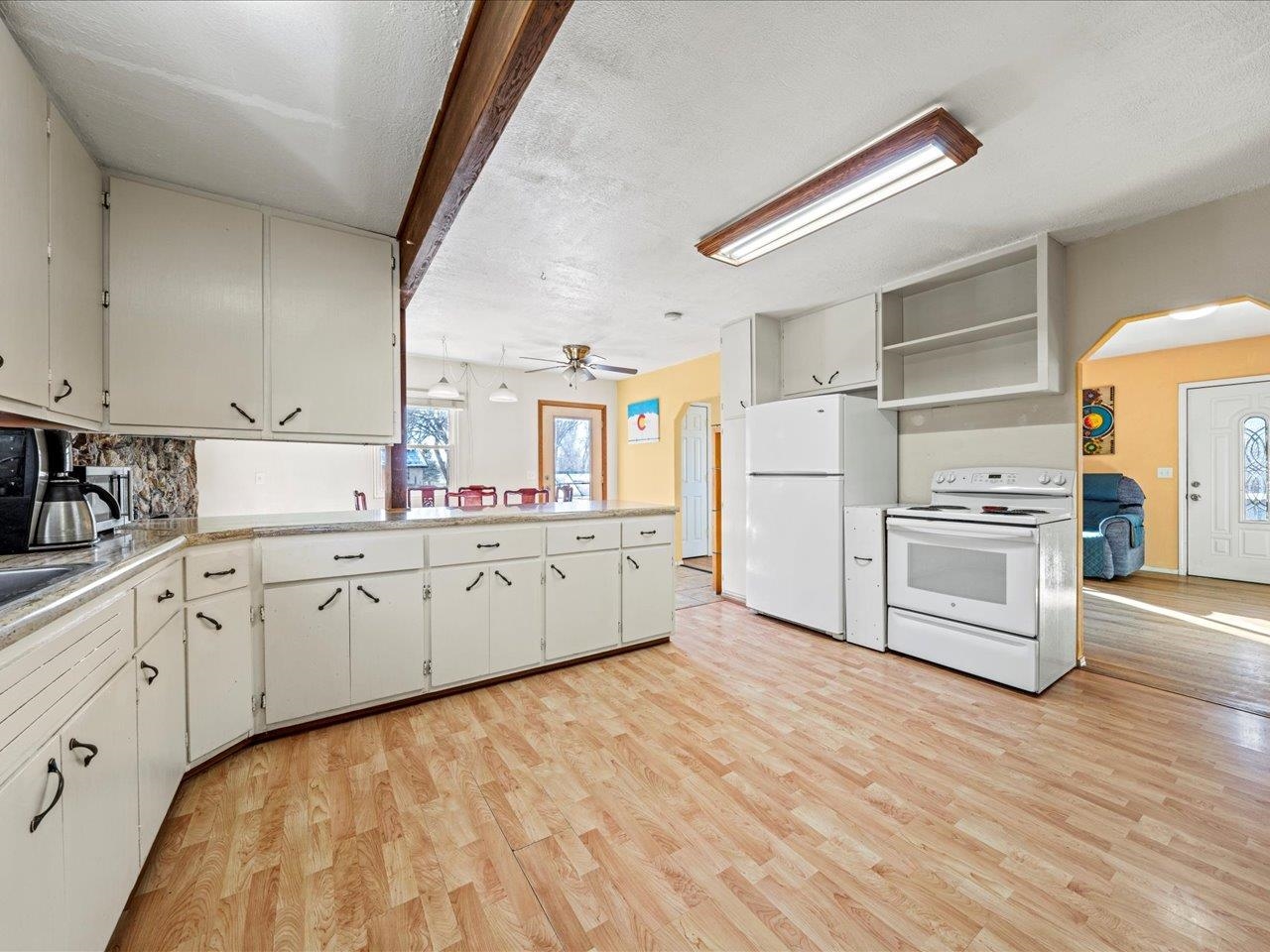 608 Bluff Street Delta, CO 81416 - Photo 17 of 42 a kitchen with granite countertop white cabinets and white appliances