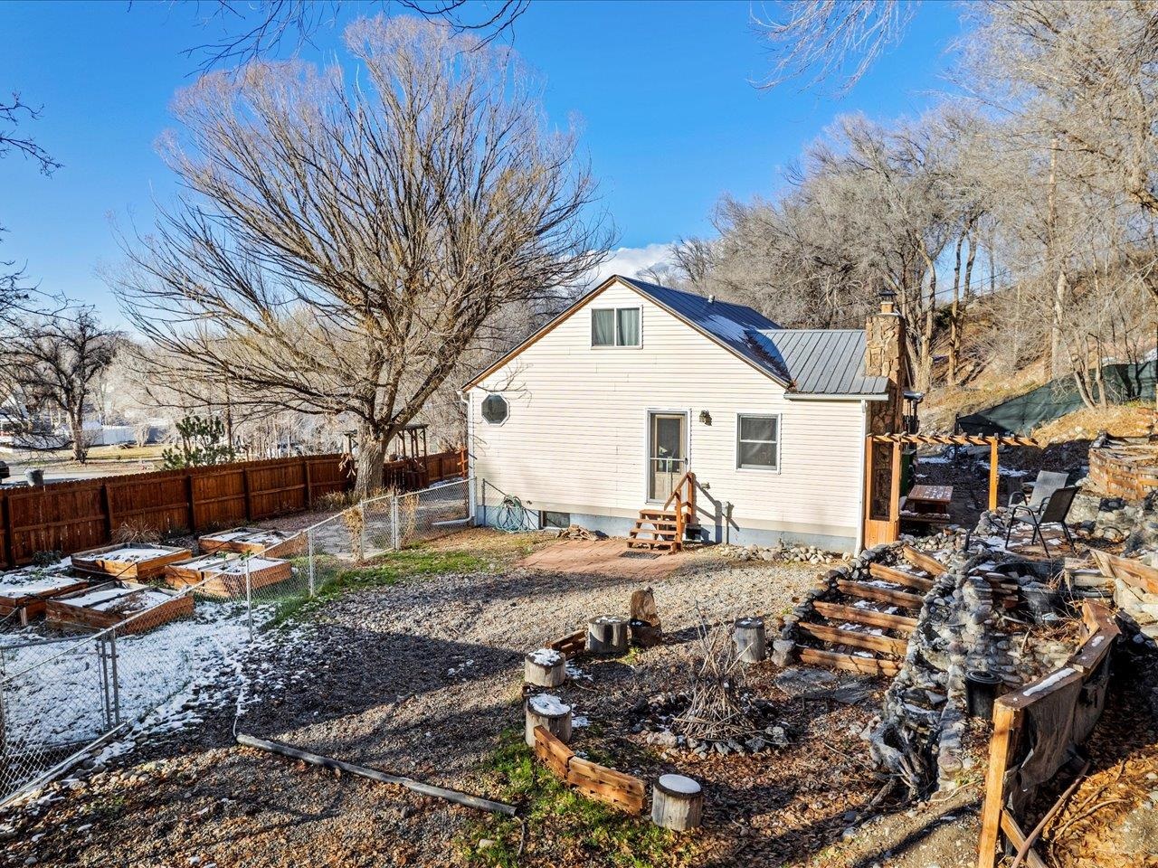 608 Bluff Street Delta, CO 81416 - Photo 9 of 42 a view of a white house with a yard covered in snow