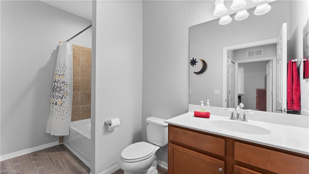 9727 Acqua Court, Unit 444 Naples, FL 34113 - Photo 11 of 25 a bathroom with a sink vanity mirror and toilet