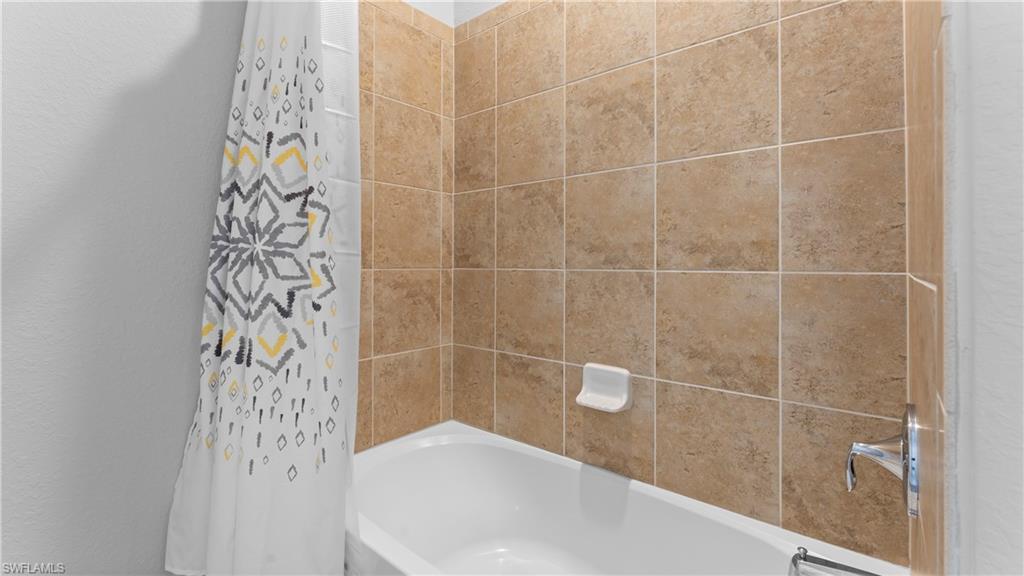 9727 Acqua Court, Unit 444 Naples, FL 34113 - Photo 12 of 25 a bathroom with a bathtub and shower