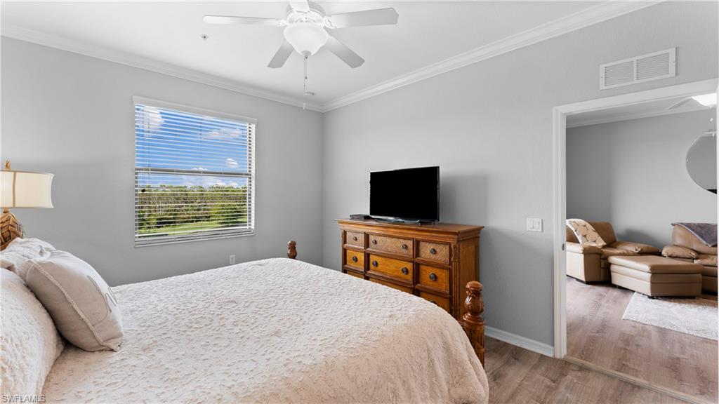 9727 Acqua Court, Unit 444 Naples, FL 34113 - Photo 14 of 25 a bedroom with a bed and flat screen tv
