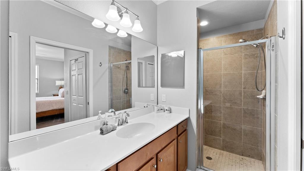 9727 Acqua Court, Unit 444 Naples, FL 34113 - Photo 15 of 25 a bathroom with a sink shower and a mirror