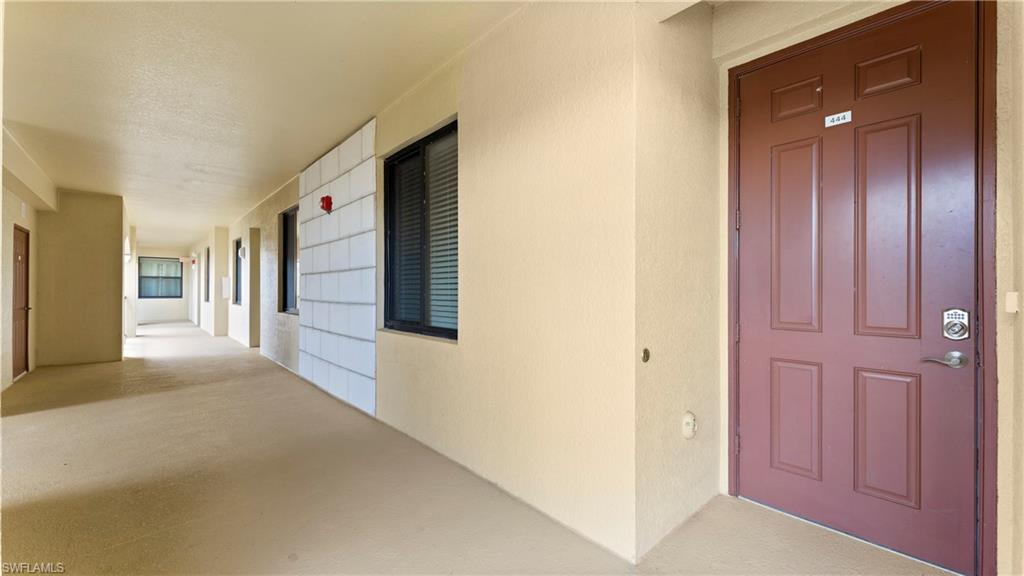 9727 Acqua Court, Unit 444 Naples, FL 34113 - Photo 18 of 25 a view of a hallway with wooden cabinets
