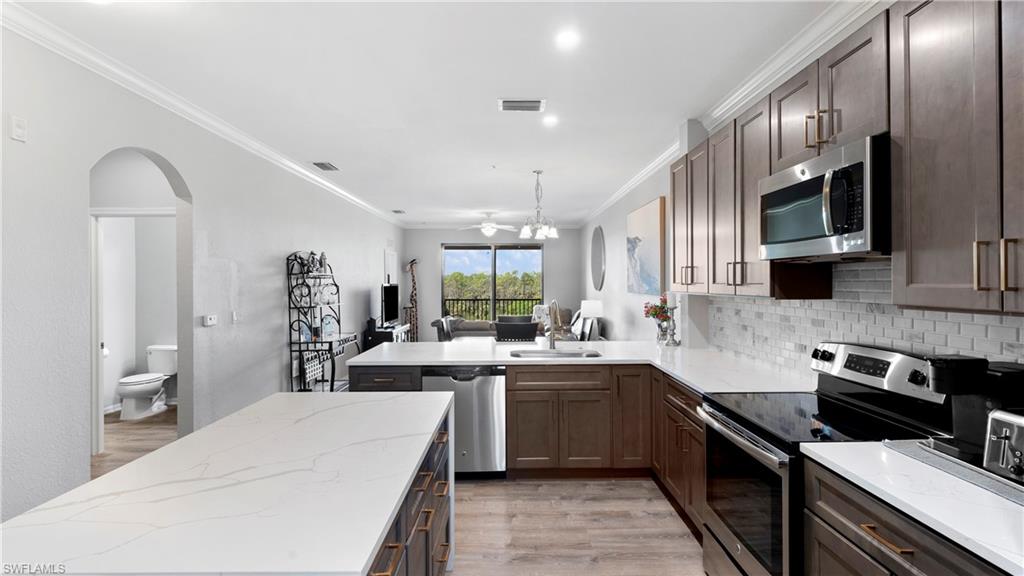 9727 Acqua Court, Unit 444 Naples, FL 34113 - Photo 5 of 25 a kitchen with a sink stove and microwave