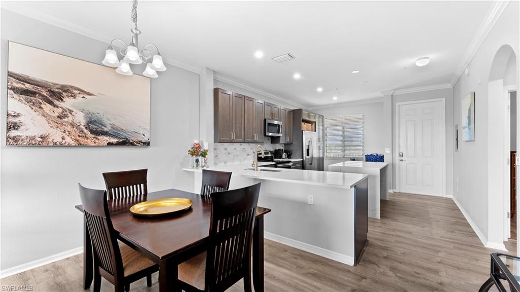 9727 Acqua Court, Unit 444 Naples, FL 34113 - Photo 7 of 25 a view of kitchen with cabinets table and chairs