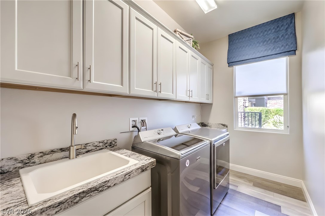 7119 Arabian Ridge Street Las Vegas, NV 89131 - Photo 60 of 73 Ample cabinetry and a utility sink offer convenience in this functional laundry room.