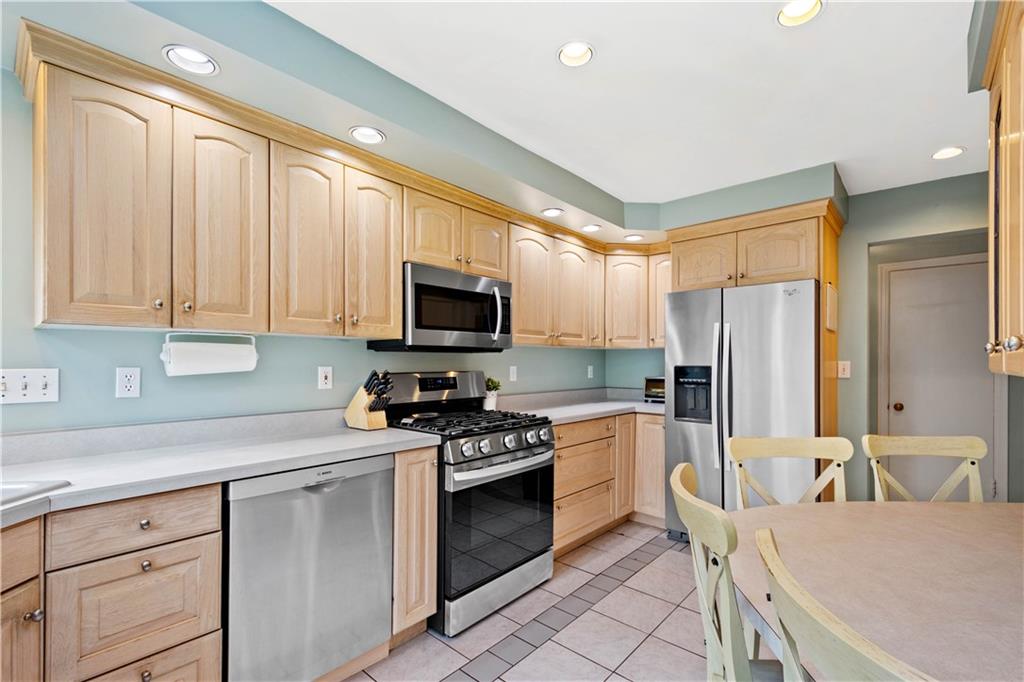 102 Conewanta Road Pittsburgh, PA 15241 - Photo 10 of 25 a kitchen with stainless steel appliances a stove sink microwave refrigerator and cabinets
