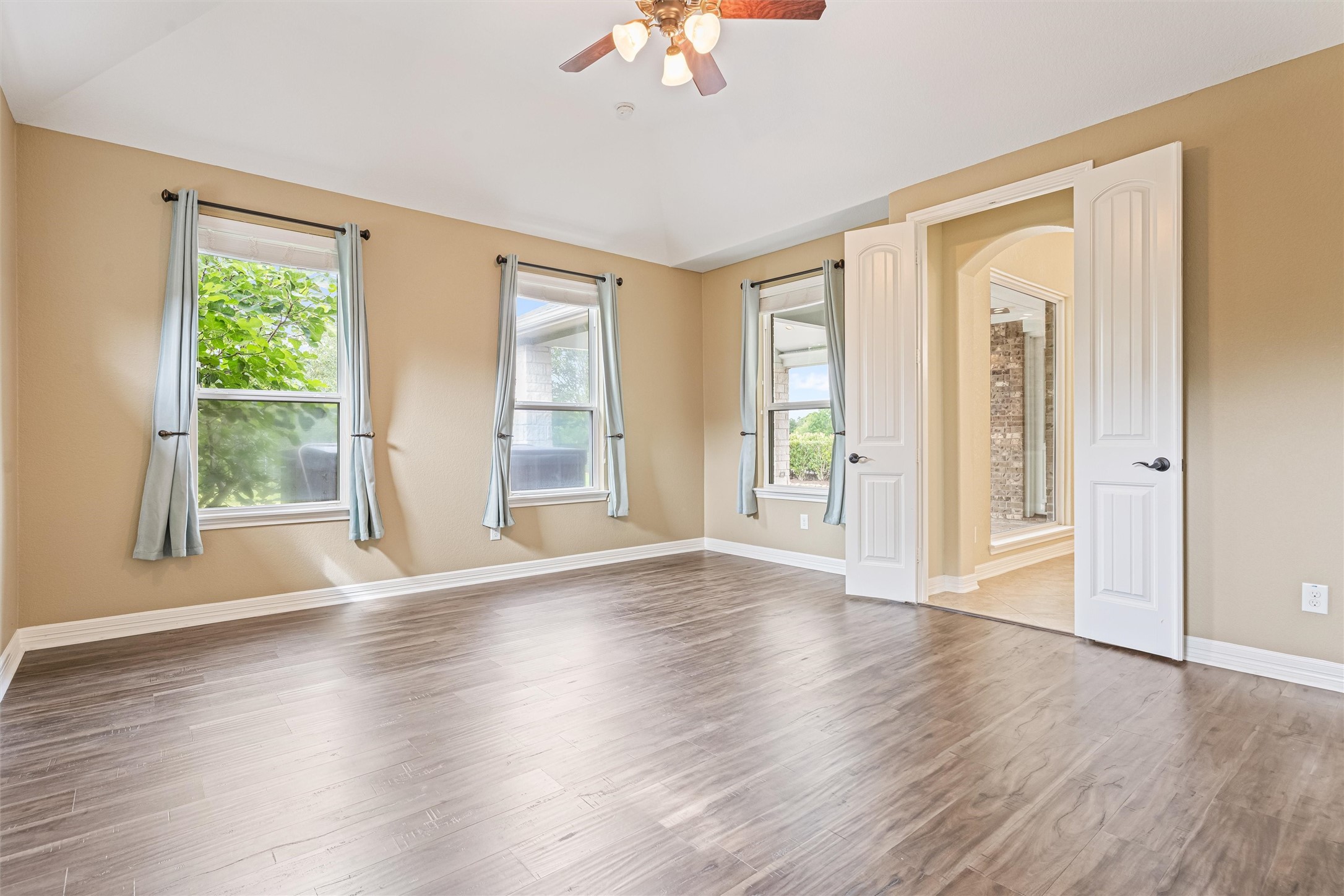 27714 Linden Ridge Lane Fulshear, TX 77441 - Photo 9 of 48 The primary bedroom is filled with light, and features a luxury plank vinyl floor and mansard ceiling