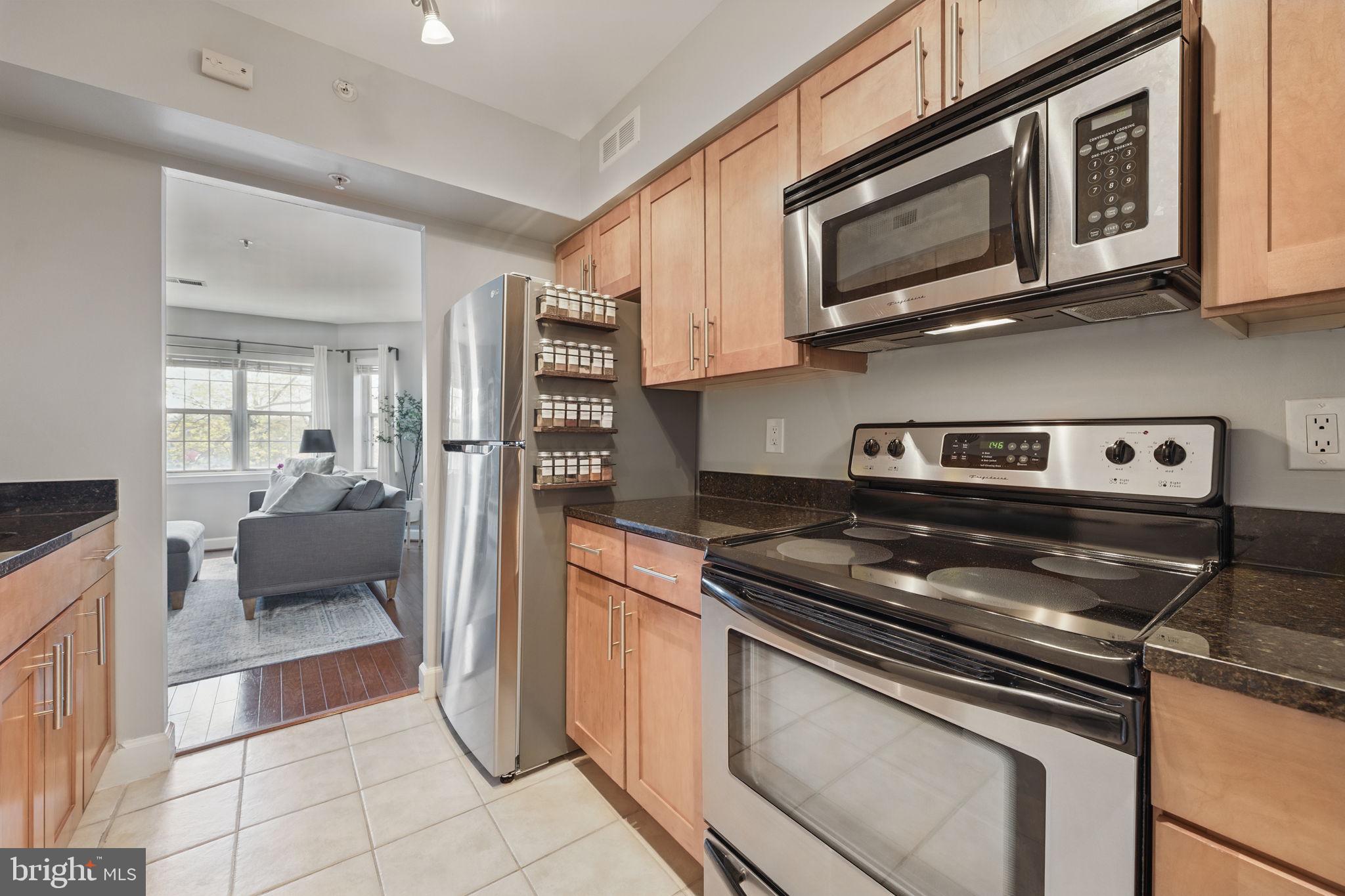 3611 38th Street Northwest, Unit 209 Washington, DC 20016 - Photo 9 of 30 a kitchen with stainless steel appliances granite countertop a stove microwave and refrigerator